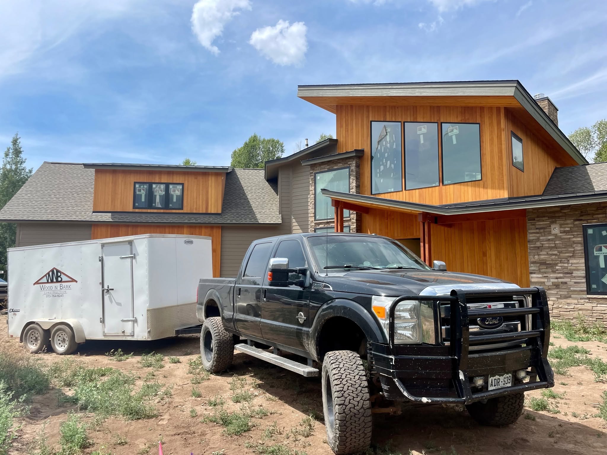 Contemporary wood and stone home in progress with Wood N Bark work vehicles