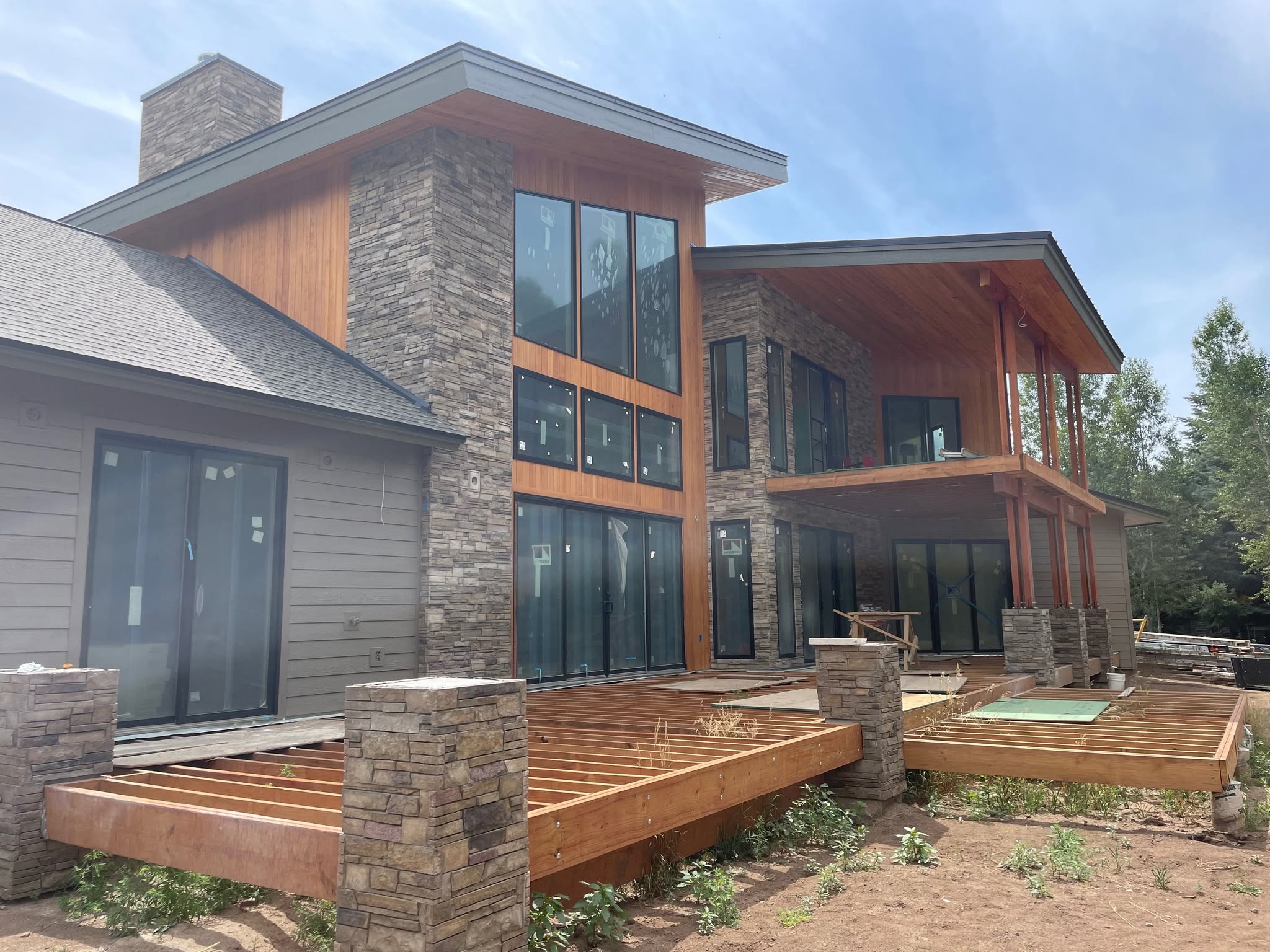 Large contemporary mountain home in progress with wood, stone and tall glazing